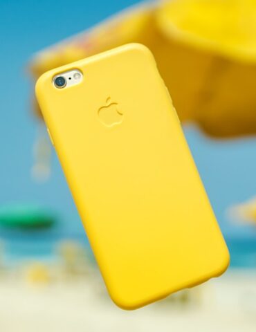 iPhone with yellow cover hanging on air