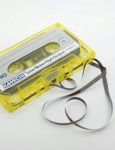 a yellow cassette cassette with a black strap